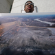 There are dozens of coal ash ponds in the path of Hurricane Florence. Here, Johnny Collins, of Kernersville, North Carolina, holds a photo of a Duke Energy coal plant during a protest near the company’s headquarters in 2014.